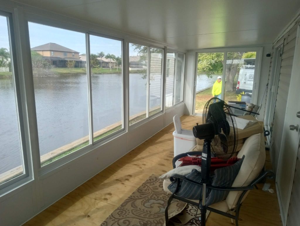 Interior of insulated Florida room showing large glass windows overlooking canal waterway