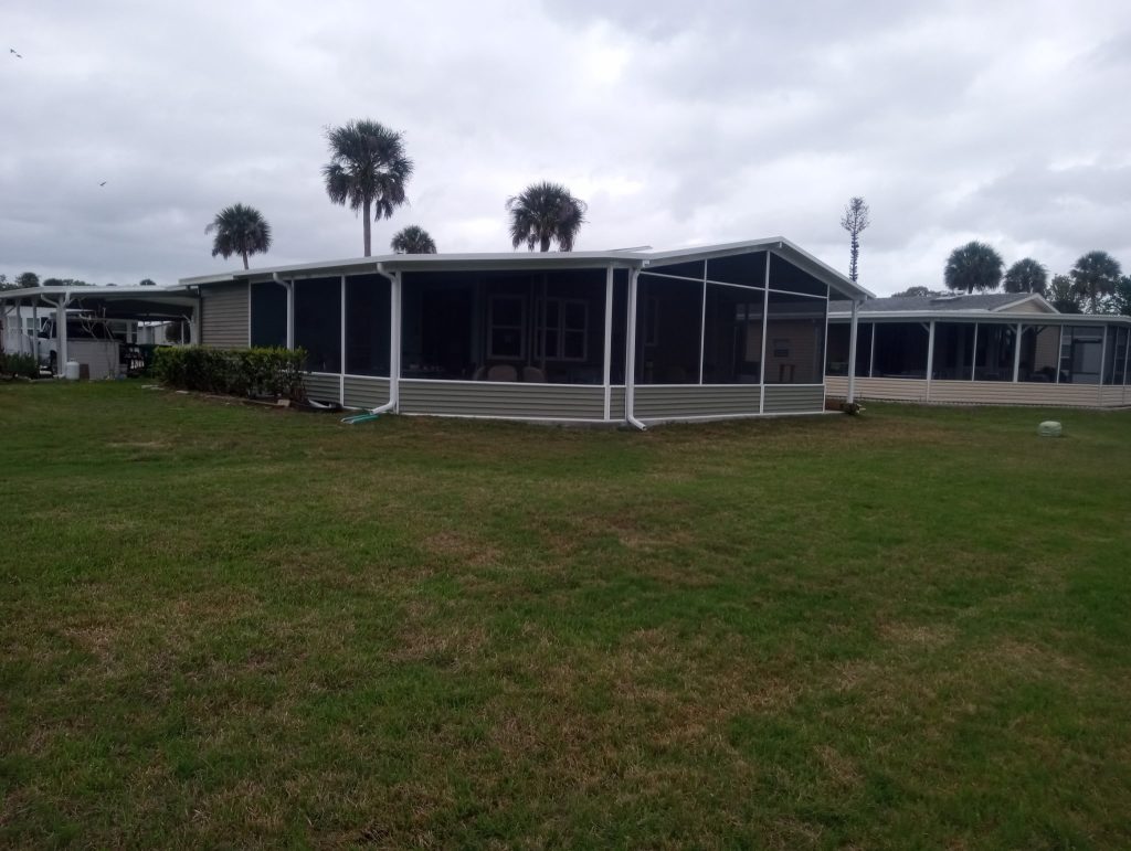 Large insulated wrap-around room addition with vinyl siding extending from existing shed in Cocoa Florida