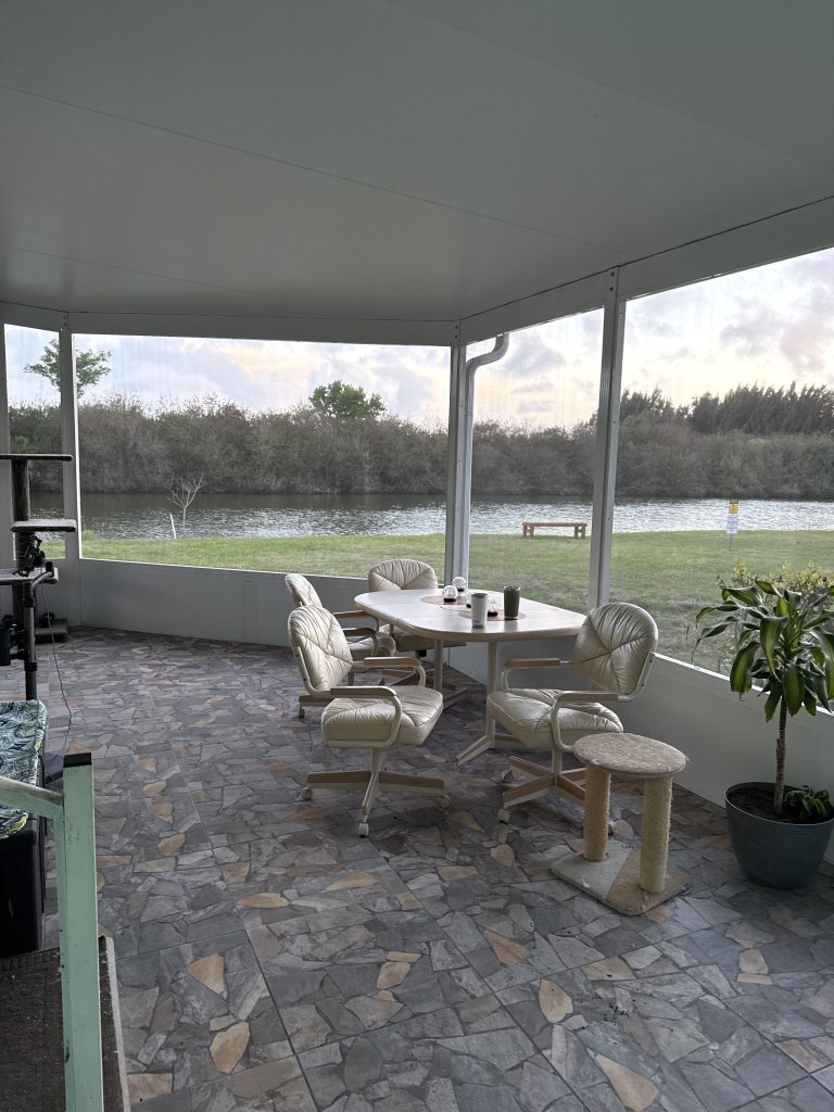 Full exterior view of completed insulated wrap-around room with vinyl siding at Cocoa home
