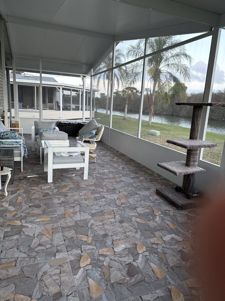 Corner view of aluminum wrap-around room showing insulated roof panels and vinyl siding in Cocoa