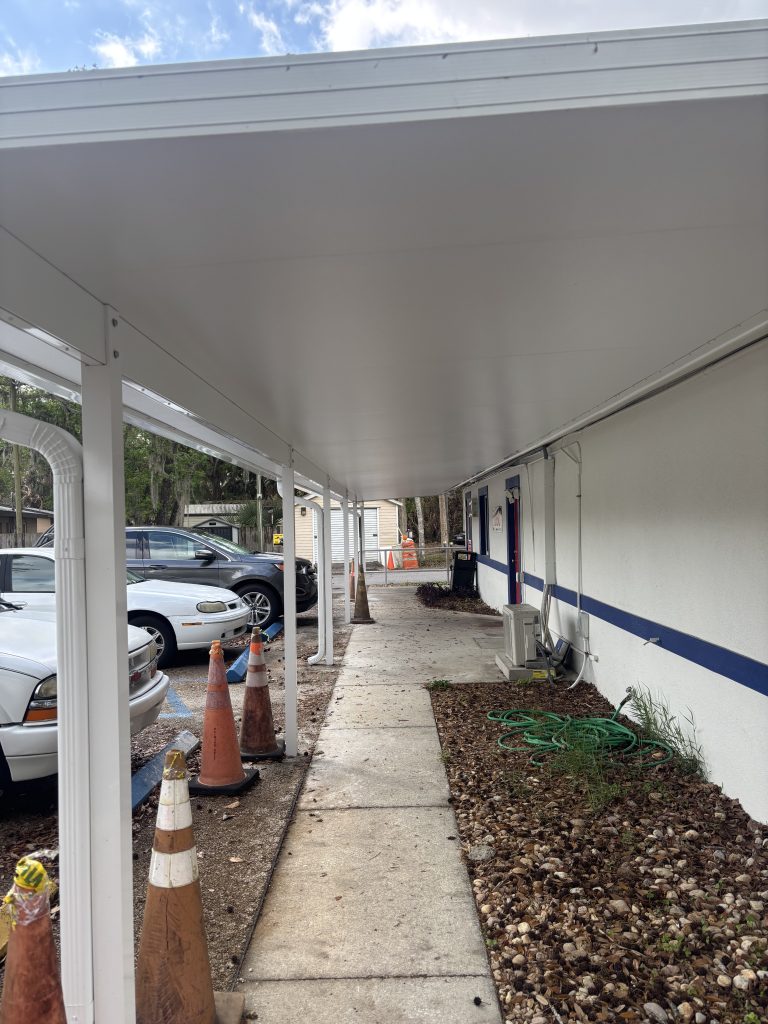 Completed insulated walkway cover with aluminum posts cemented into concrete at American Legion Titusville