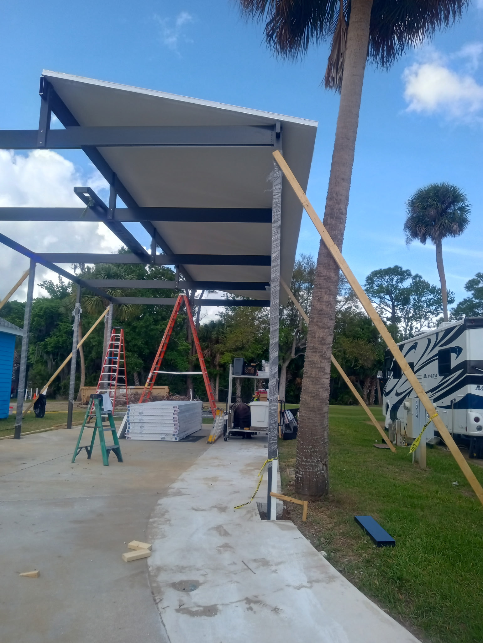 Aluminum motorhome carport during framing showing structural post layout in Titusville