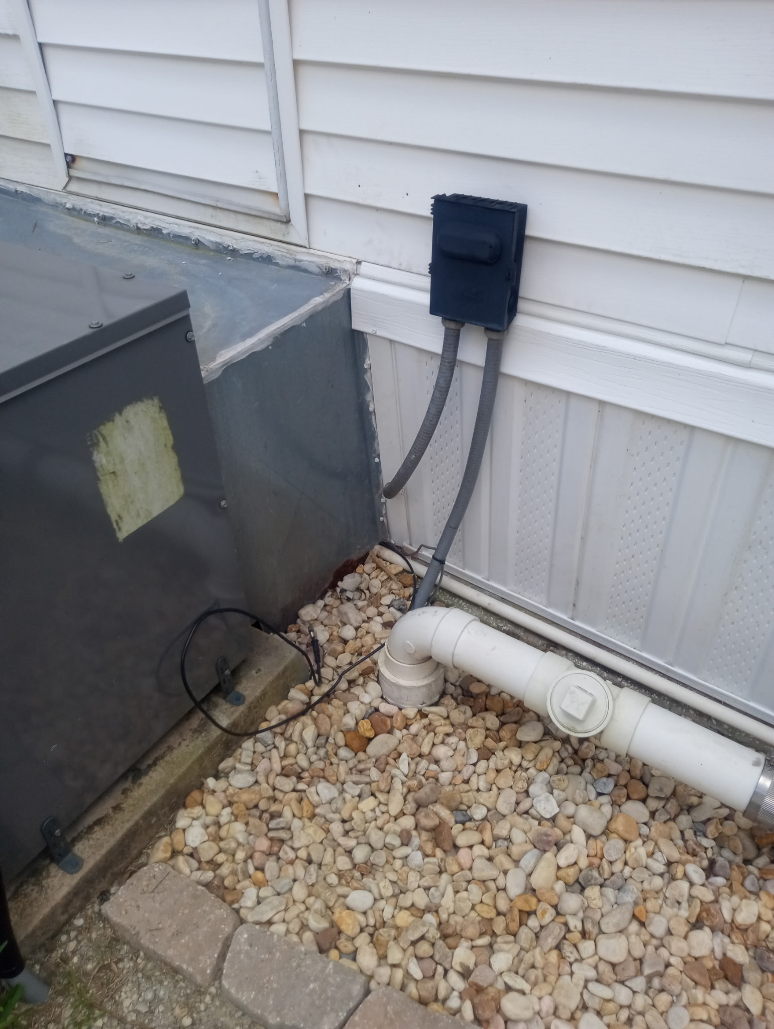 Vinyl skirting custom fit around electrical disconnect and PVC drain plumbing on Titusville mobile home