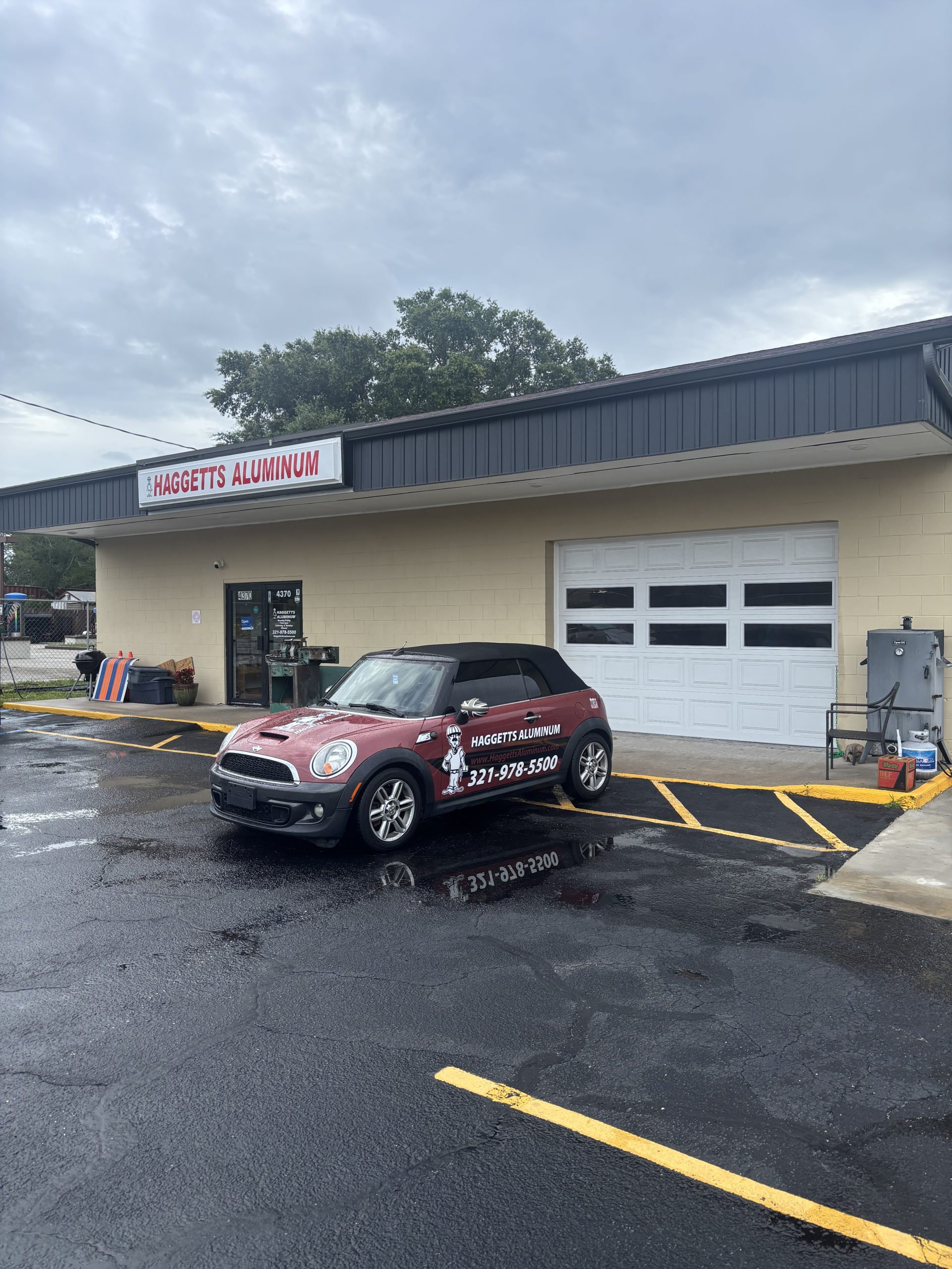 Haggetts Aluminum Mini Cooper parked in front of the Haggetts Aluminum shop
