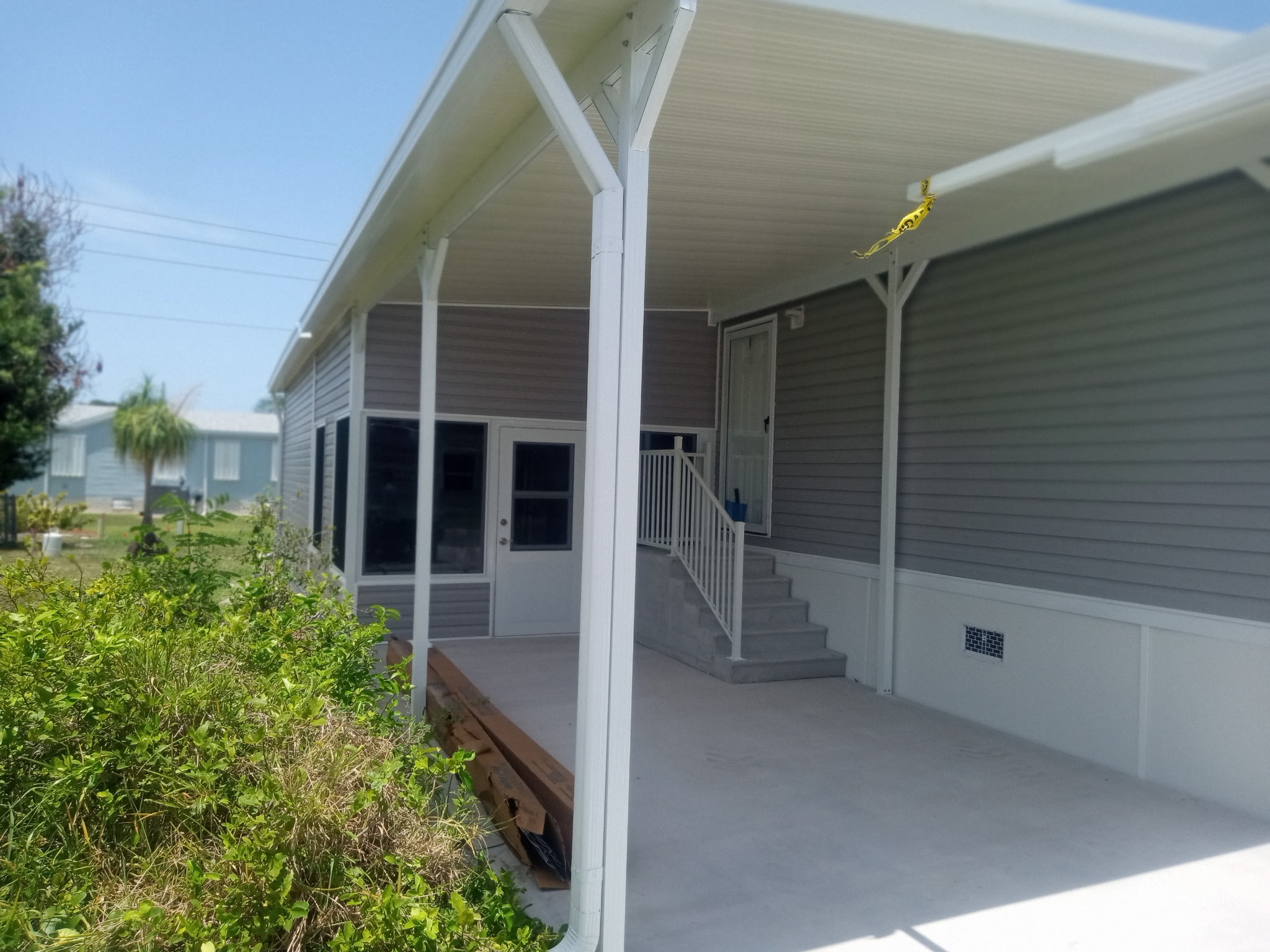 Aluminum roofline connecting shed carport and Florida room on manufactured home in Barefoot Bay